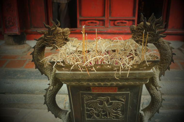 A bronze incense burner flanked by dragons